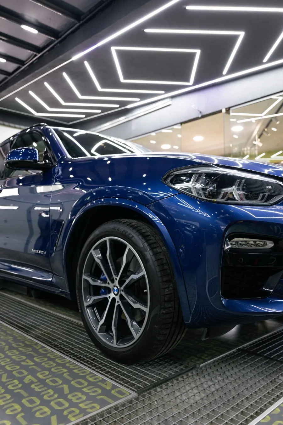 A ceramic-coated car under showroom light strips